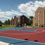 Basketball court with apartment building in the background.