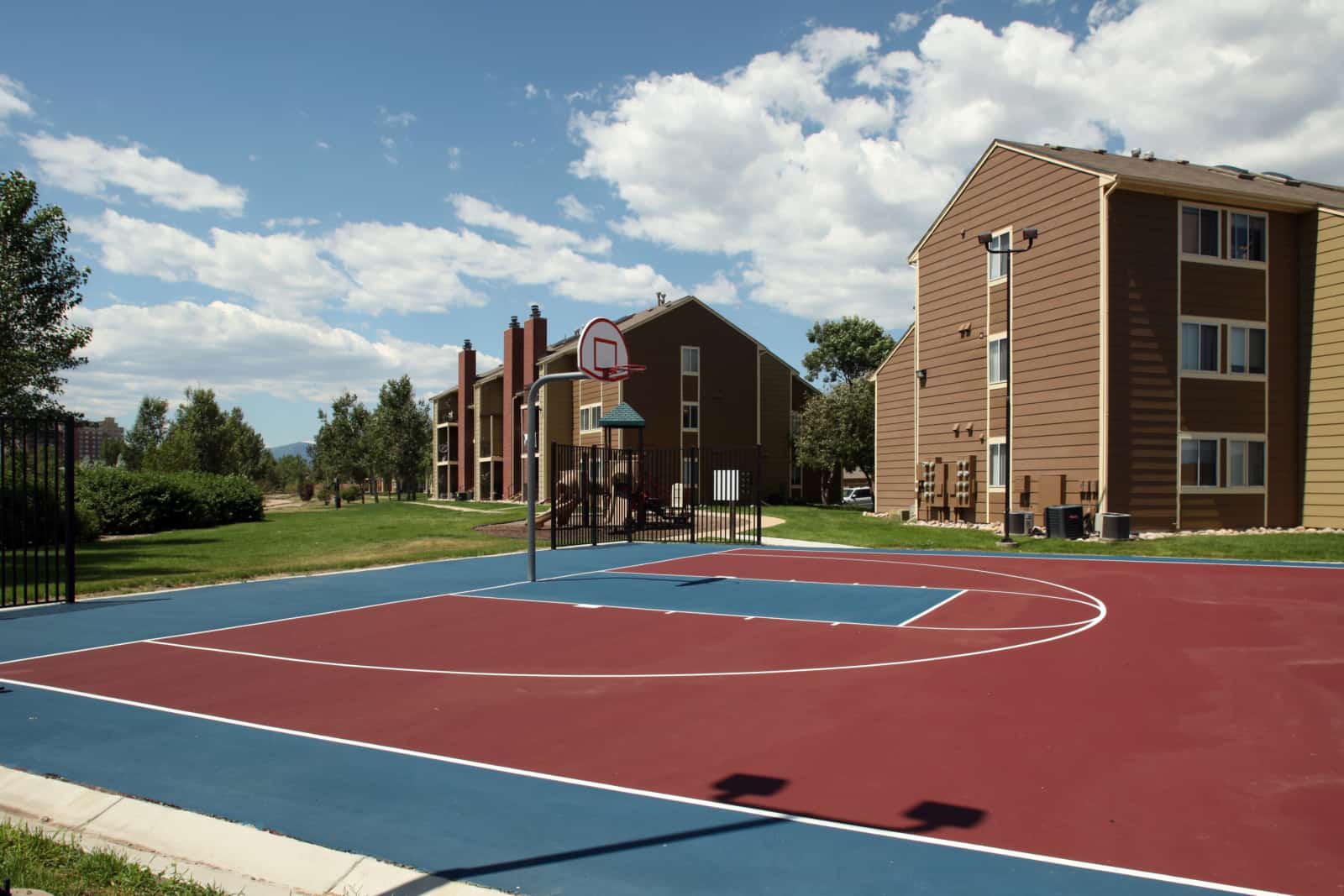Basketball court with apartment building in the background.