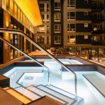 Exterior of large tiled spa pool with apartment complex in background