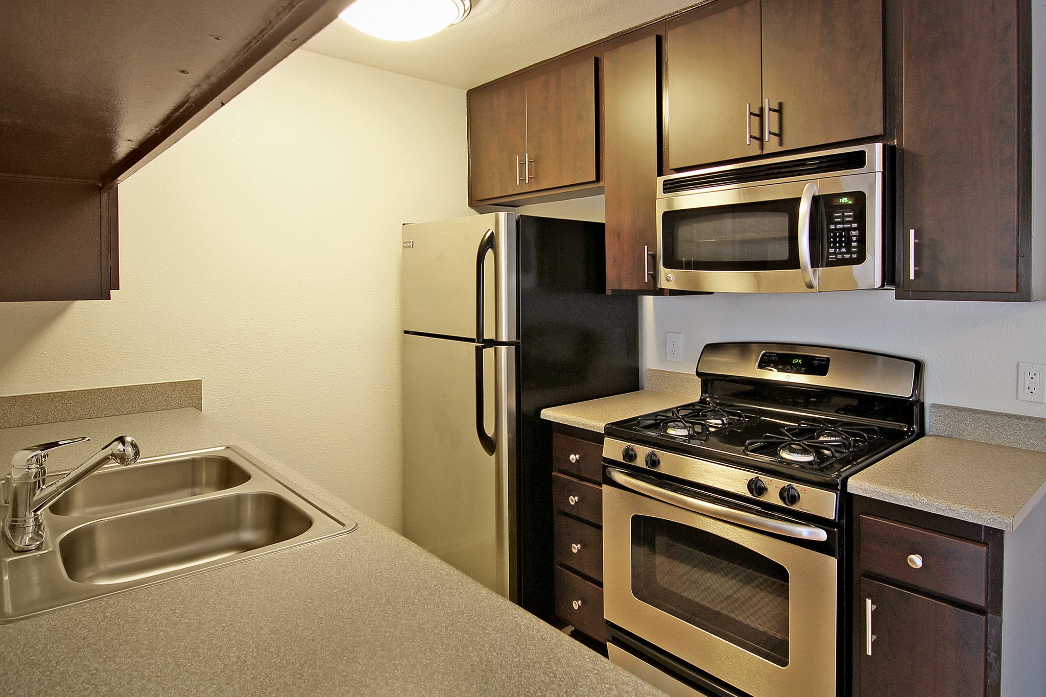 Galley kitchen with stainless steel appliances.