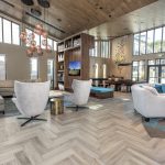 Modern interior with seating areas with couches, high ceilings and pool table