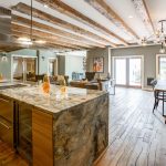 Interior of large open room with kitchen, dining table, and living room area.