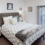 Interior of apartment bedroom with sliding doors onto balcony.