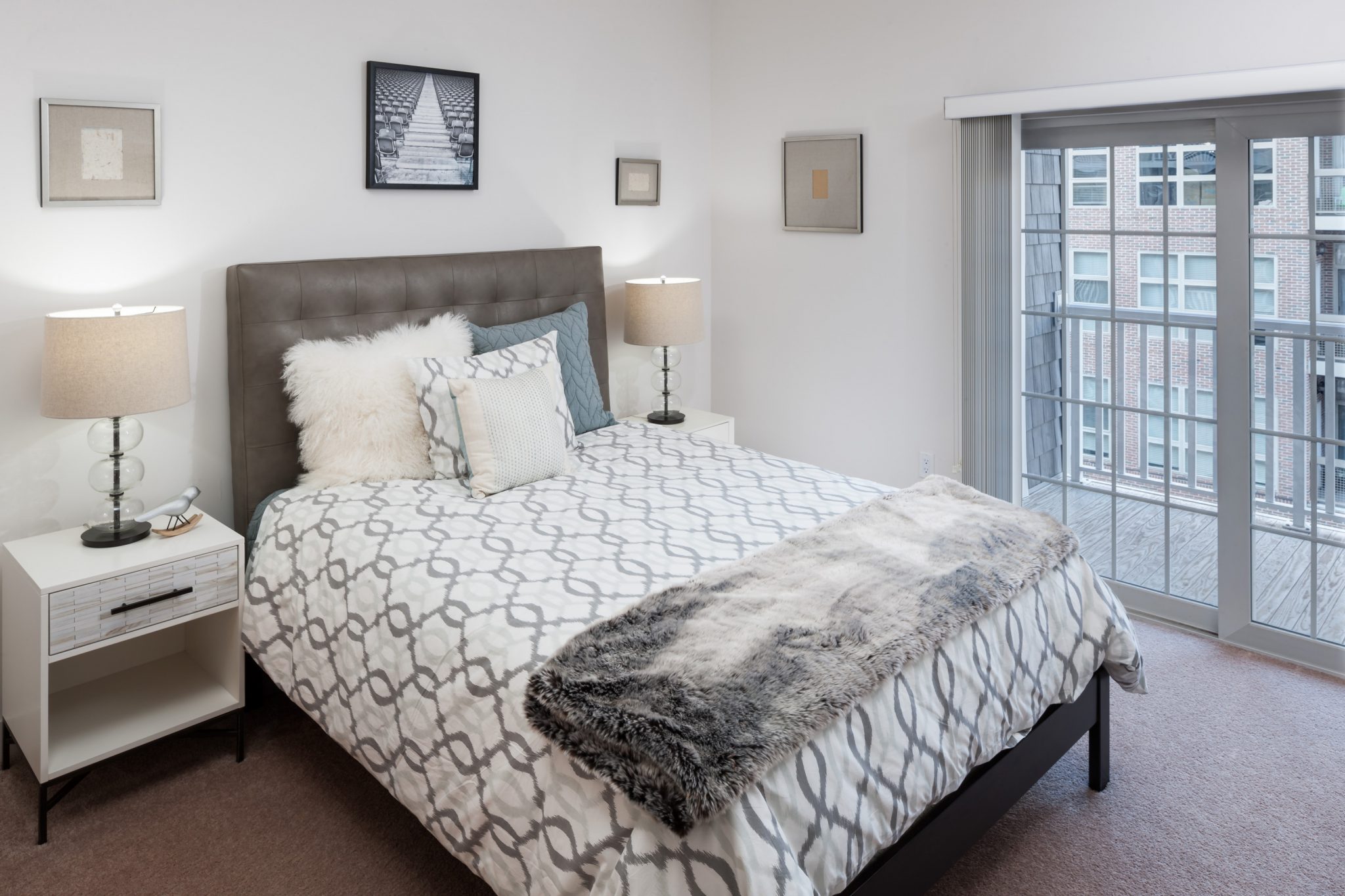 Interior of apartment bedroom with sliding doors onto balcony.
