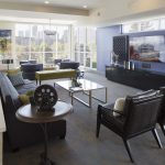 Interior of common area with couch, modern chairs and large-screen television.