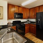 Interior of kitchen with black appliances.