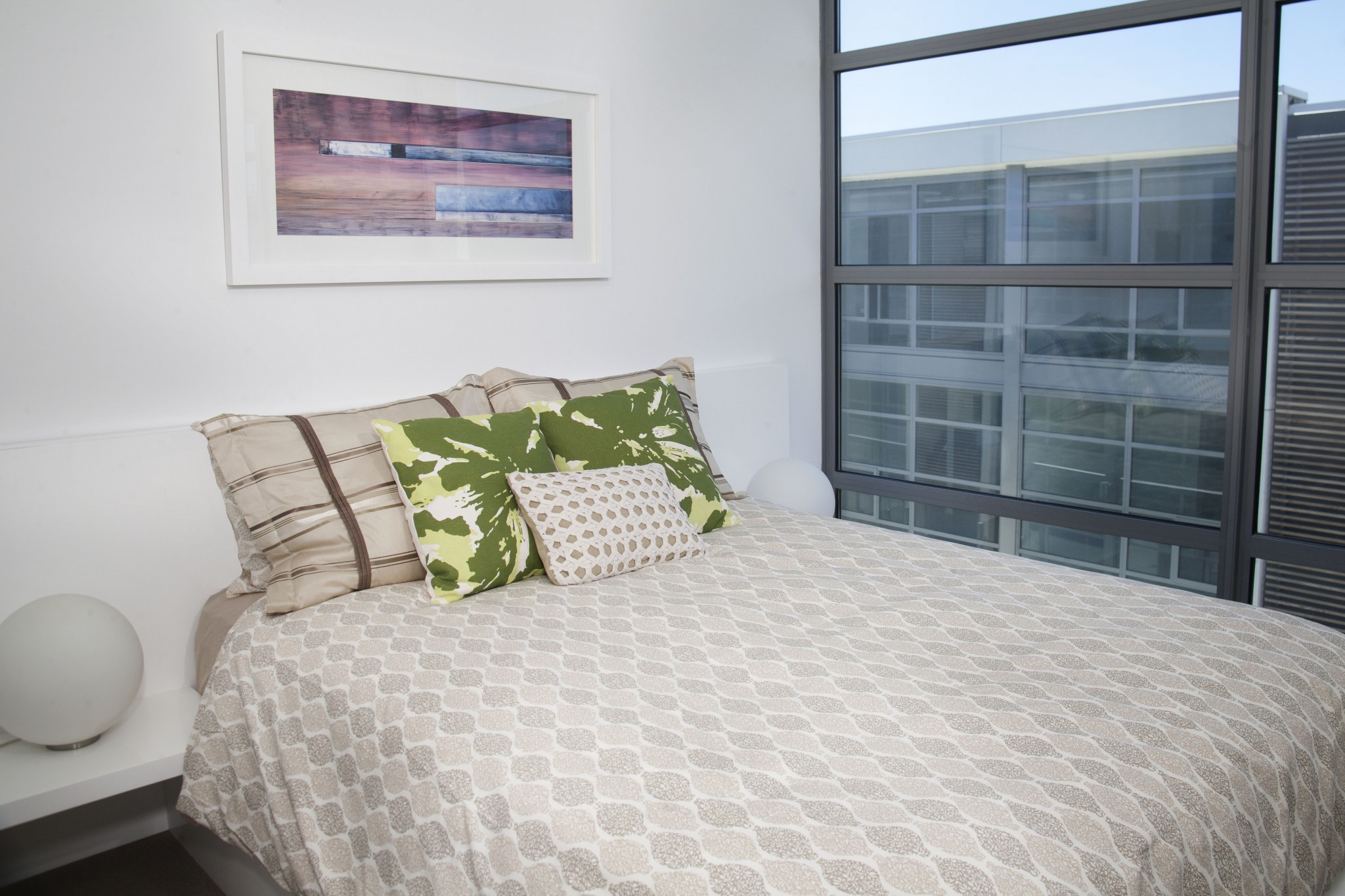 Interior of bedroom featuring large windows.
