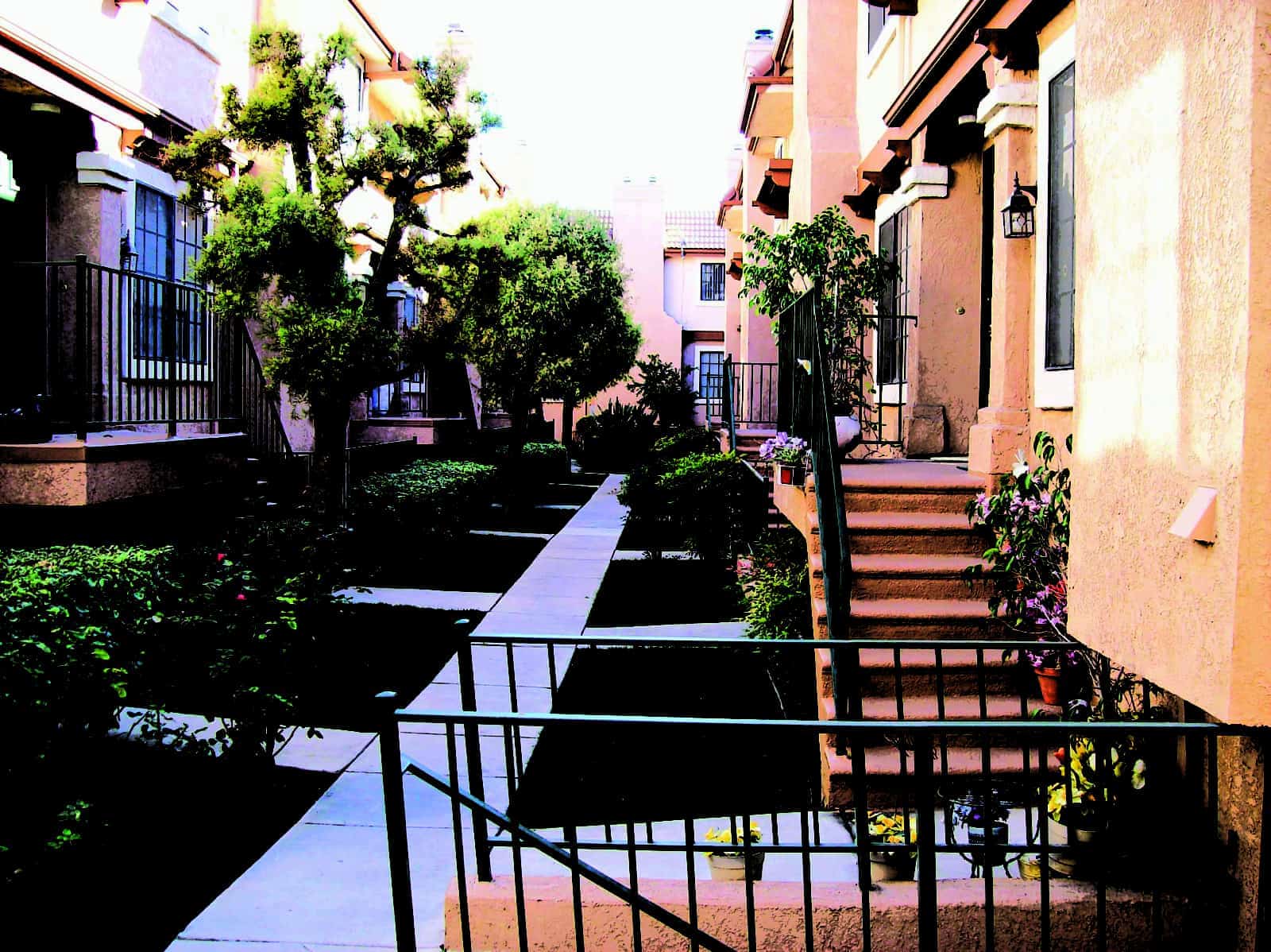 View of the walkway between two buildings and staircases to the entrances of the units.