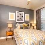 Interior of bedroom with yellow and grey decor.