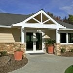 Exterior view of single story clubhouse building with double door entrance.