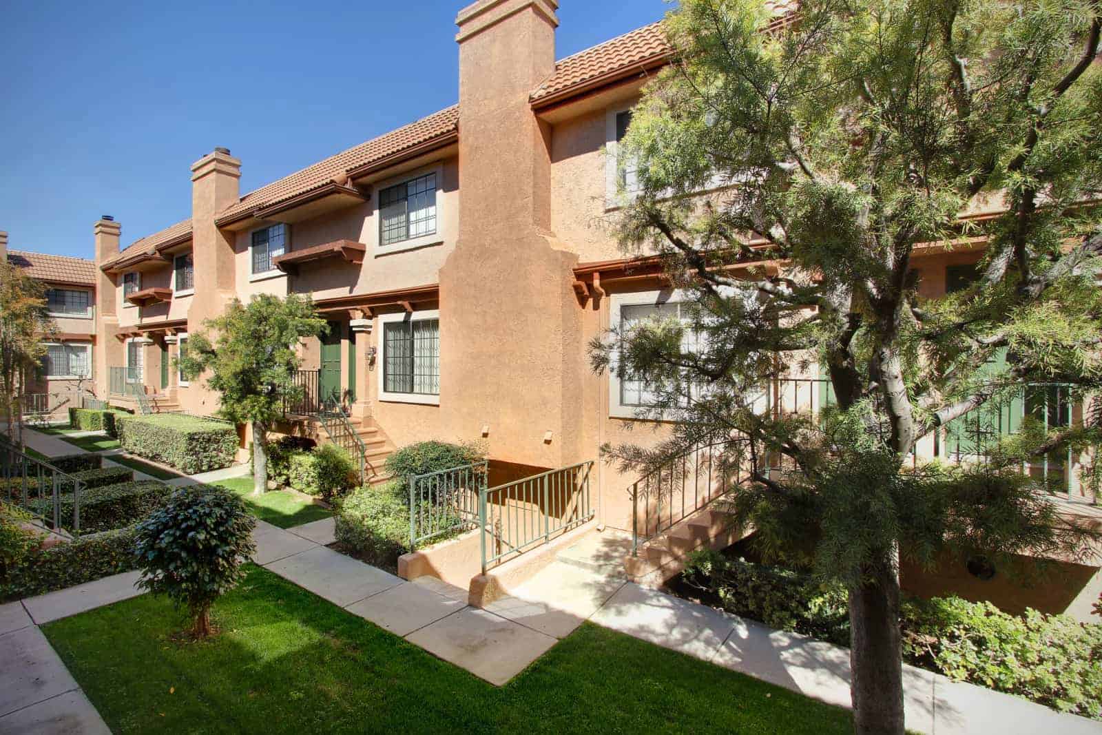Exterior of a 2 story building with stairs that lead up to the front doors.