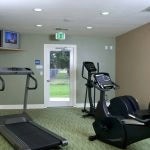 View of the fitness center with 3 cardio machines and a TV.