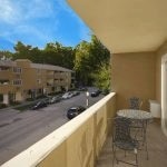 View of balcony with table and chairs and the building across the street.