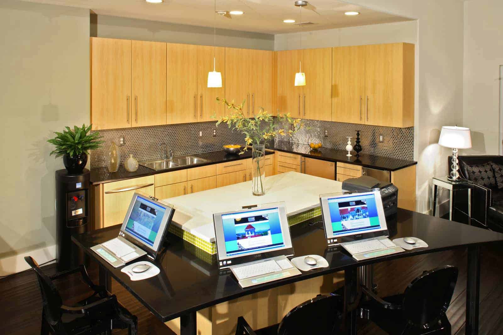 Common area kitchen with laptops on a counter in the foreground.