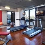 Fitness center with several exercise machines, dumbbells, and physio balls.