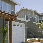 View of a row of 2 story buildings with garages.