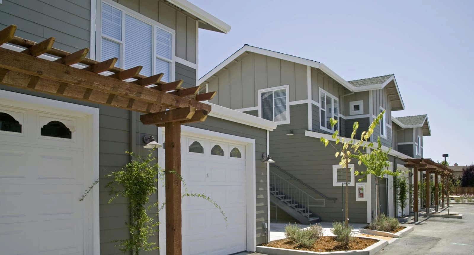 View of a row of 2 story buildings with garages.