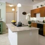 View of the kitchen with black appliances and granite countertop.