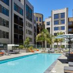 Exterior of swimming pool, lounge chairs, umbrellas in courtyard