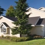 Exterior of a yellow, 2 story building with pitched roofs.