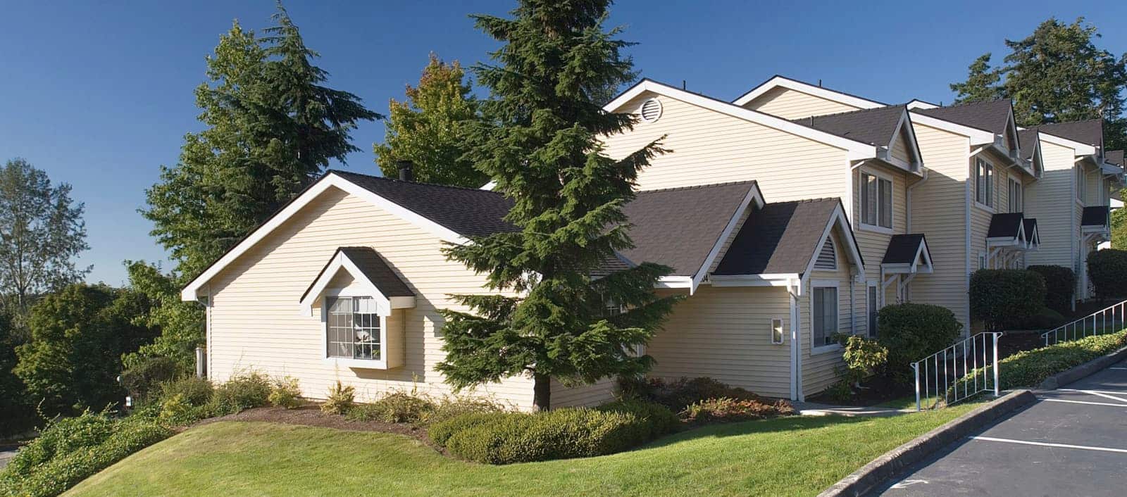 Exterior of a yellow, 2 story building with pitched roofs.