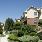 View of a walkway flanked by landscaping between buildings.