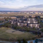Aerial exterior of entire apartment complex with baseball fields in the foreground and horizon in background
