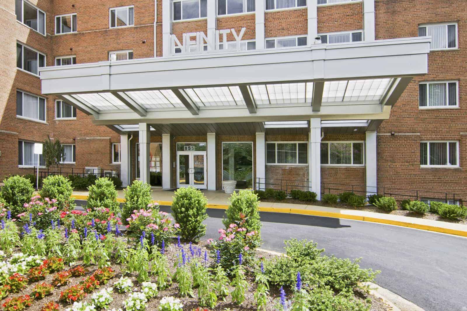 Entrance to building with a flower bed in the foreground.