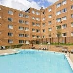 View of the pool with the apartment building in the background.