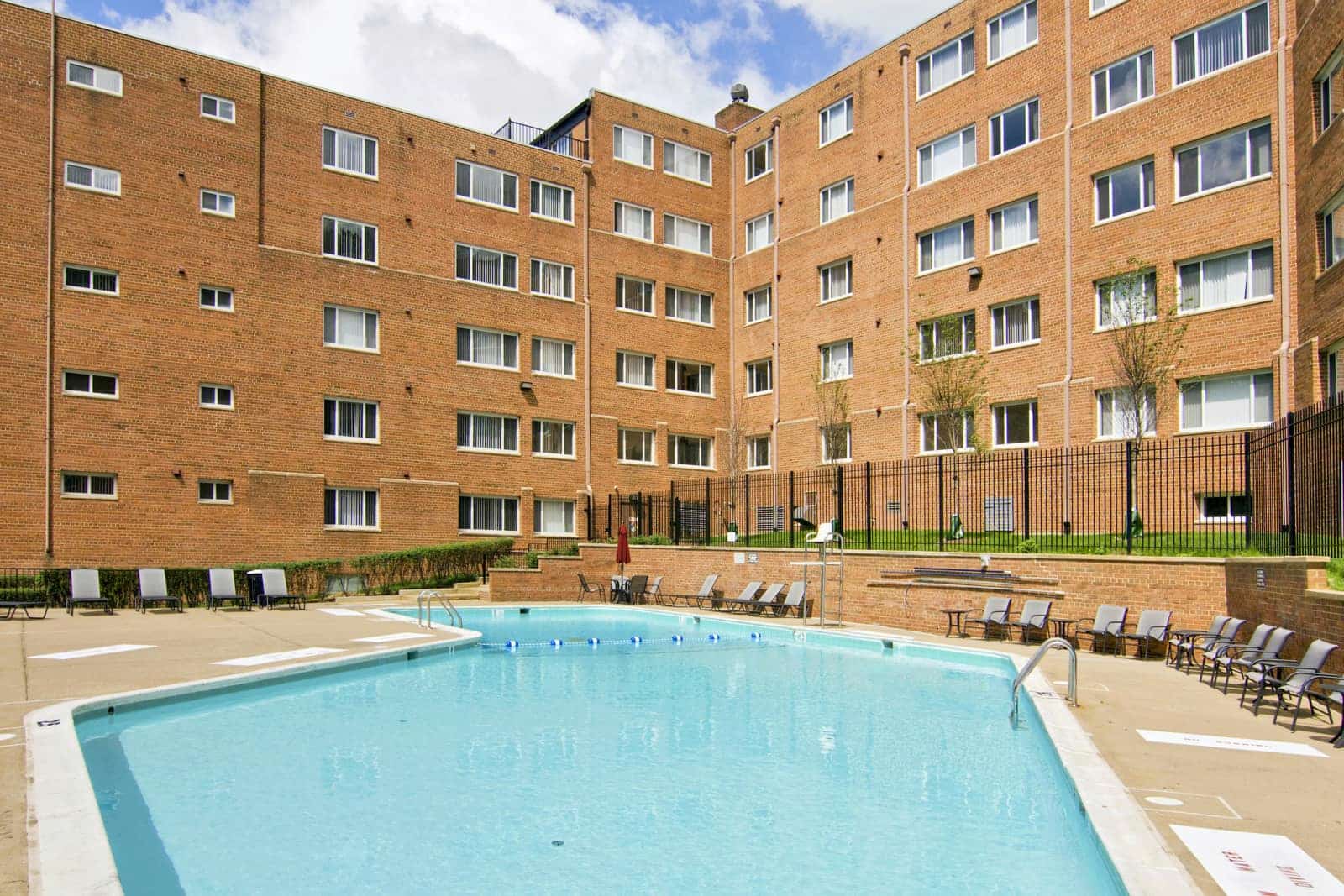View of the pool with the apartment building in the background.