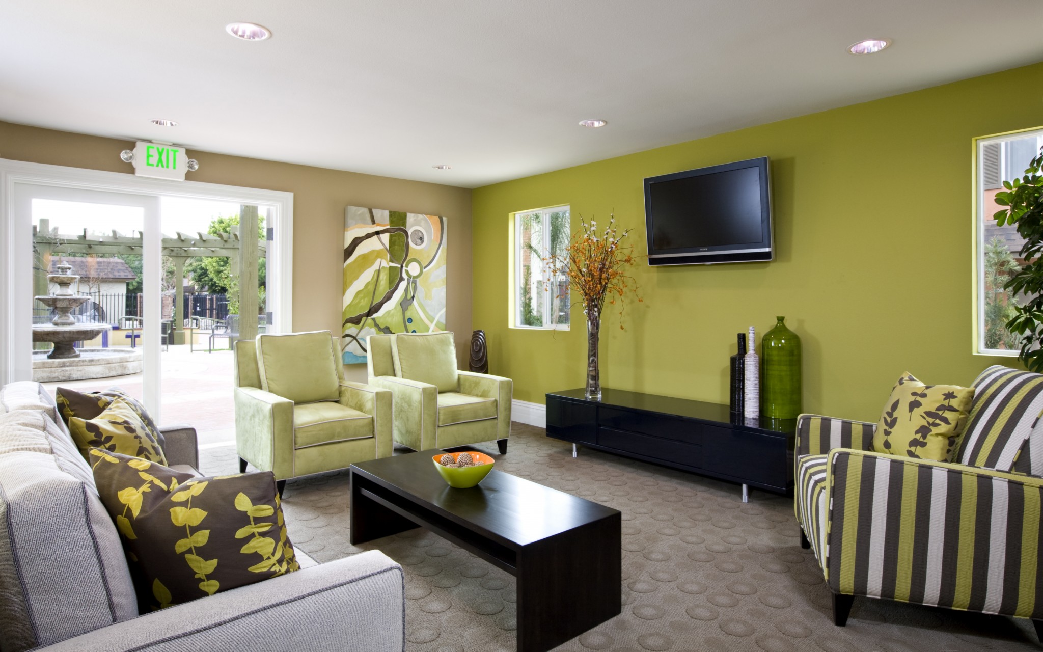 Interior of clubhouse with couch, chairs, coffee table, and TV.