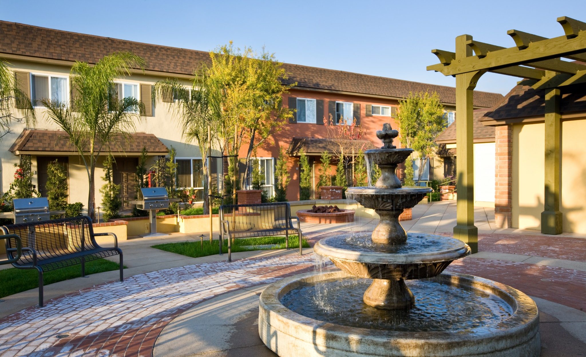 View of outdoor bbq area, fire pit and fountain in the foreground.