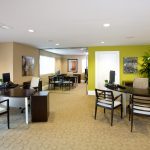 Apartment office with several desks and chairs set up.