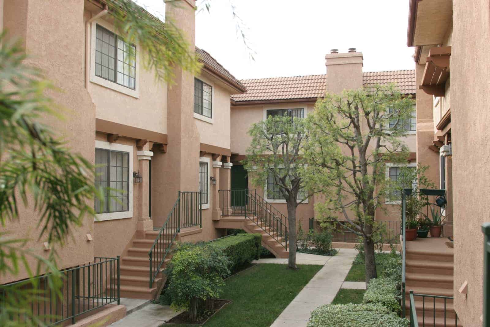 View of the walkway between two buildings and staircases to the entrances of the units.
