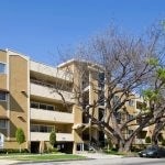 Exterior of 3 story apartment building with balconies from across the street.
