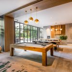Modern interior common space with tables, chairs, and billiard table.
