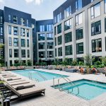 Exterior of swimming pool and spa surrounded by modern lounge chairs in a courtyard