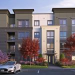 Exterior of entrance to 4-story apartment building with parking lot in foreground