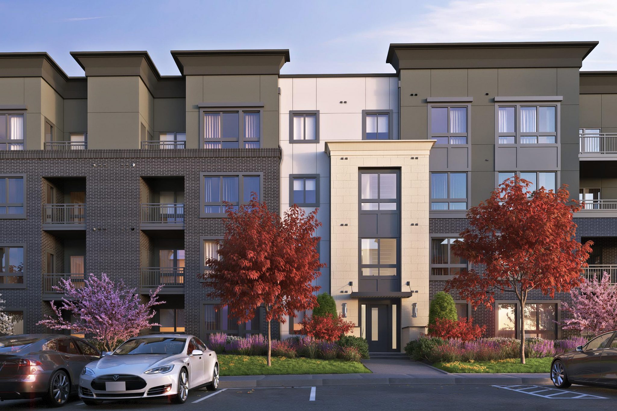 Exterior of entrance to 4-story apartment building with parking lot in foreground
