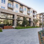 Exterior of modern apartment building with paved walkway in foreground