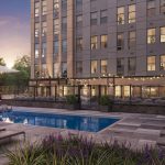 Exterior with swimming pool, deck with lounge chairs, with multistory apartment building in background