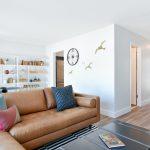 Apartment living room interior with leather couch and bookshelves