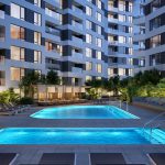 Exterior of pool deck with two pools and lounge chairs surrounded by modern apartment building