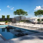 Exterior of rooftop pool deck with pool, lounge chairs, sun umbrellas, and trees with city views in background