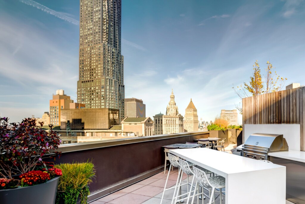 Exterior of rooftop appointed with barbeque and countertop-height dining area