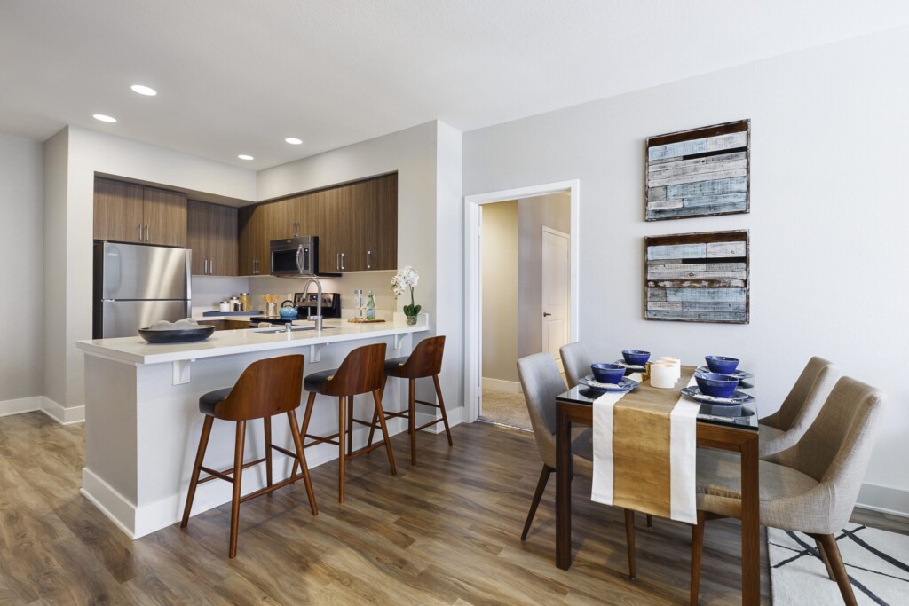 Apartment interior with open-plan kitchen, bar-height seating and dining table