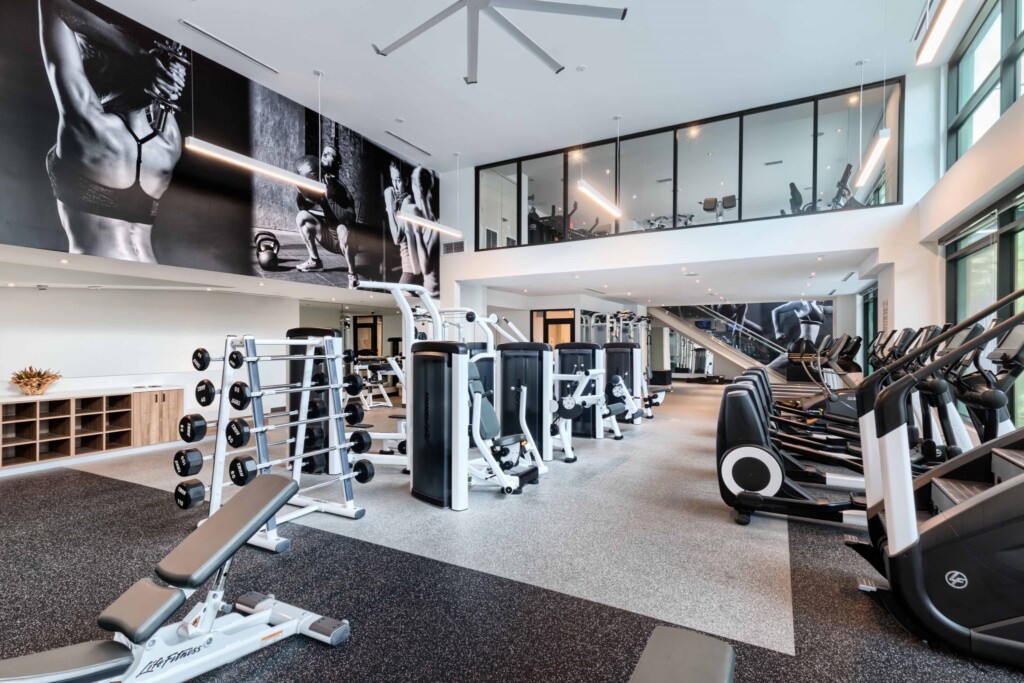 Interior of fitness center with free weights, exercise machines and high ceilings