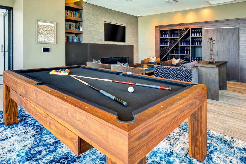 Interior of game room with pool table, fire place, large-screen television and couches