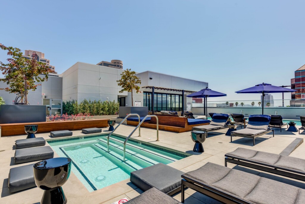 Exterior of rooftop spa surrounded by lounges, seating pads, and wooden benches