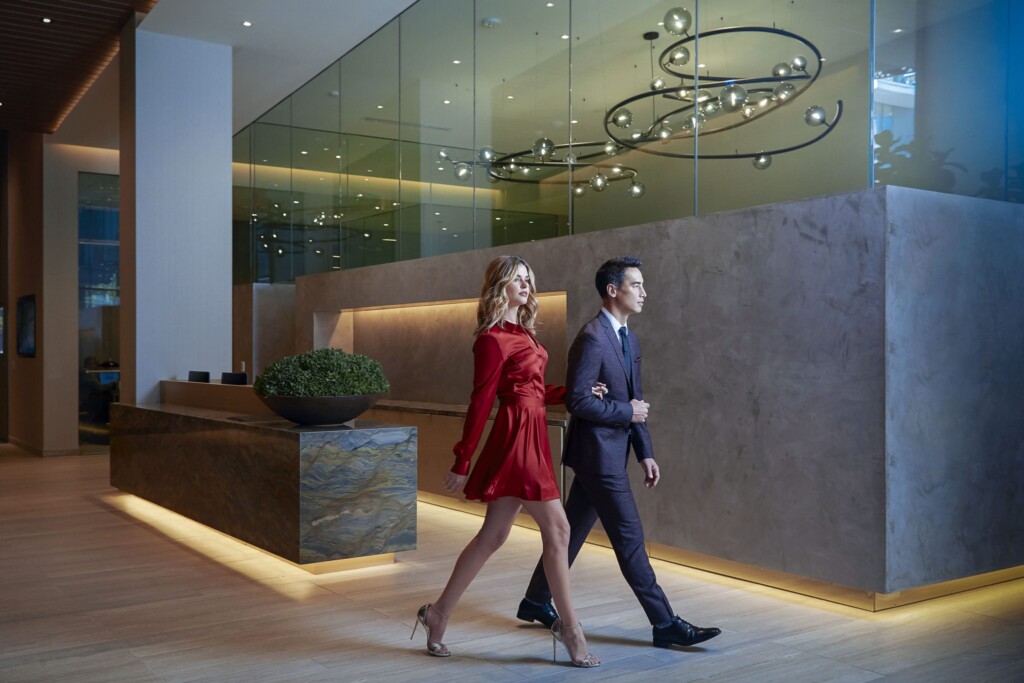 Well-dressed man and woman walking through modern lobby